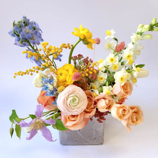 Mixed bouquet in a gray square vase with pastel flowers