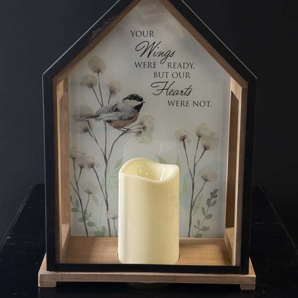 House-shaped memorial frame with a candle and bird illustration