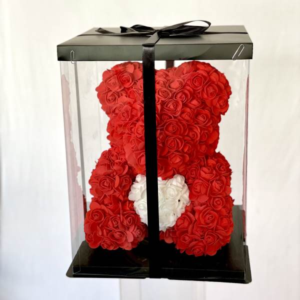 Red teddy bear made of roses in a clear gift box with a black ribbon