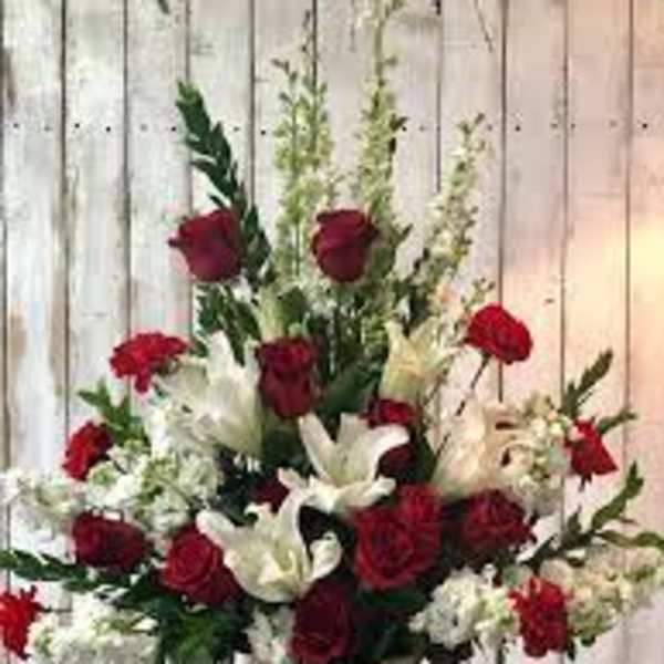 Red roses and white lilies arranged in a white vase