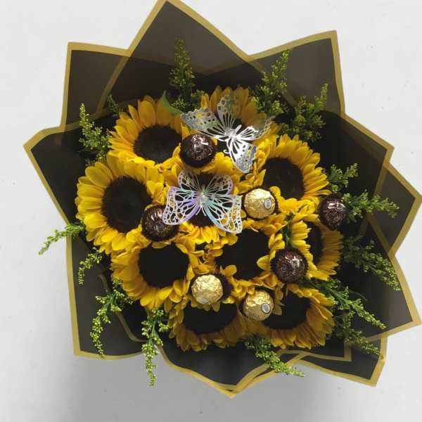 Bouquet of sunflowers with chocolates and butterfly decorations