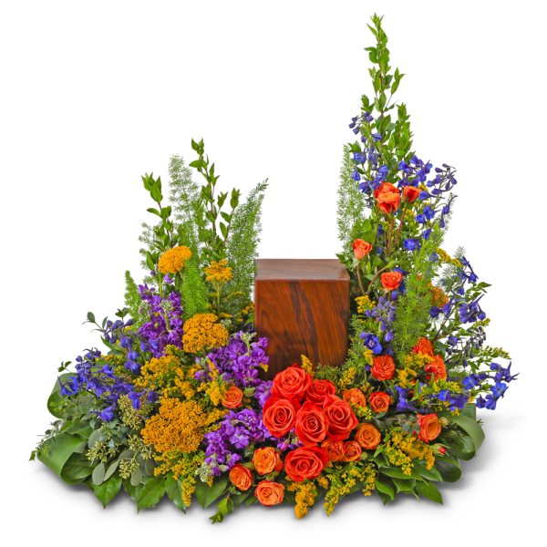 Large floral arrangement with red roses, purple flowers, and yellow accents around a wooden urn
