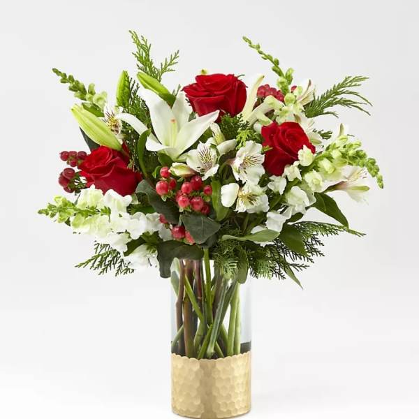 Red roses and white lilies in a glass vase with gold wrap