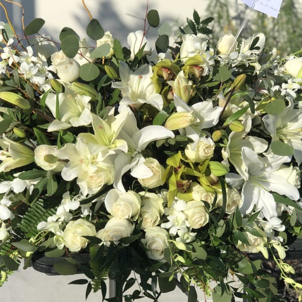 Large white floral spray with lilies, roses, and orchids