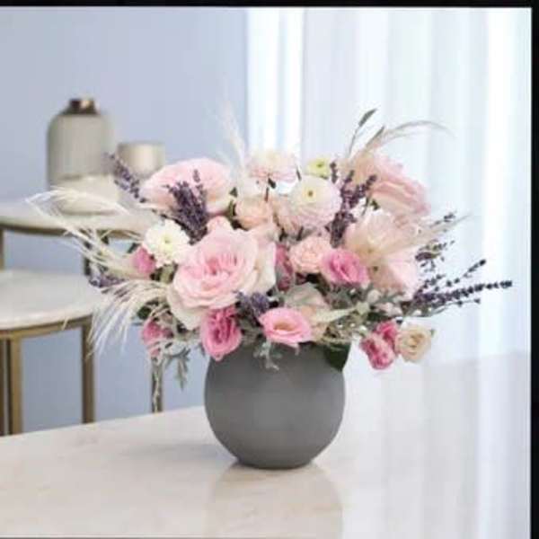 Pink and white flower arrangement in a gray vase