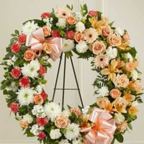 Floral wreath with roses, daisies, and lilies on an easel
