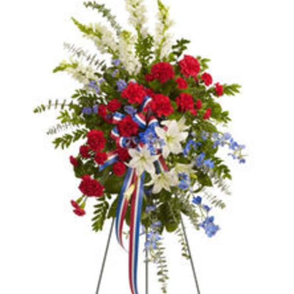 Standing floral spray with red, white, and blue flowers on an easel