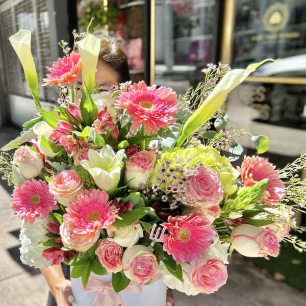 Large pink and white flower arrangement with gerberas, roses and calla lilies in a white hat box