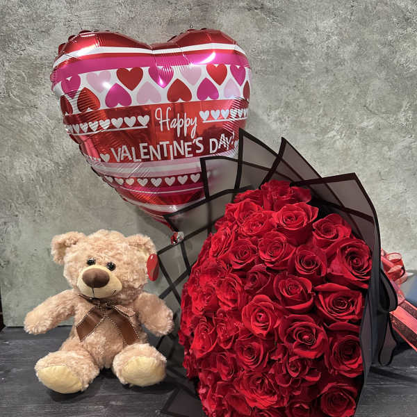 Red rose bouquet with a teddy bear and heart-shaped Valentine balloon