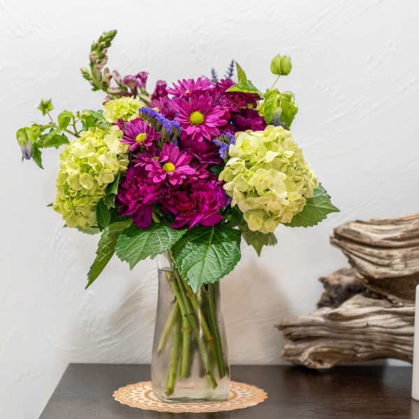 Magenta and lime hydrangea bouquet in a clear glass vase