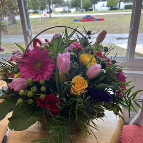 Mixed bouquet with pink tulips, roses, and a large magenta gerbera daisy