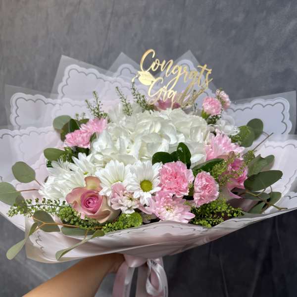 Pink and white mixed bouquet with a gold Congrats Grad topper