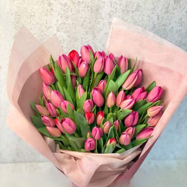 Bouquet of pink tulips wrapped in pale pink paper