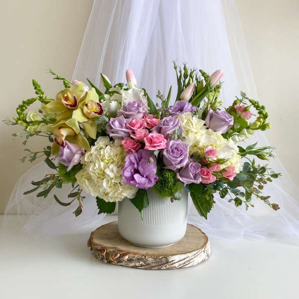 Lavender and pink floral arrangement in a white vase
