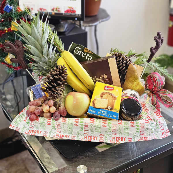 Holiday gift basket with fruit, chocolates, and a pineapple centerpiece