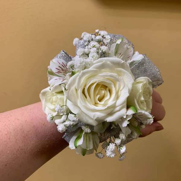 White rose wrist corsage with small white filler flowers and silver ribbon