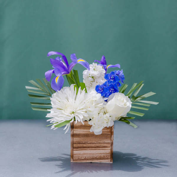 White and blue floral arrangement in a wooden box