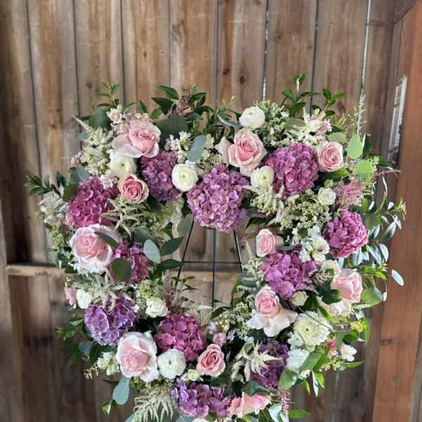 Heart-shaped floral wreath with pink roses and purple hydrangeas