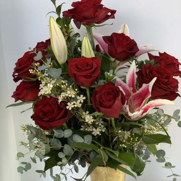 Red roses and pink lilies in a gold vase