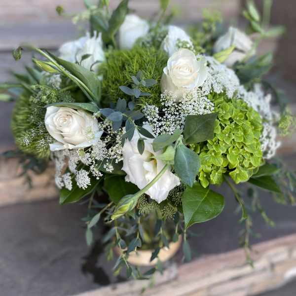 White roses and green hydrangea in a low bouquet with airy filler