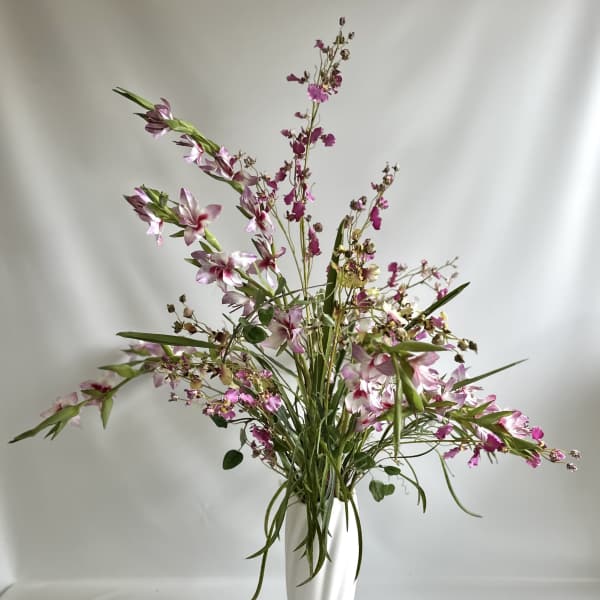 Pink and white flowers in a tall white vase