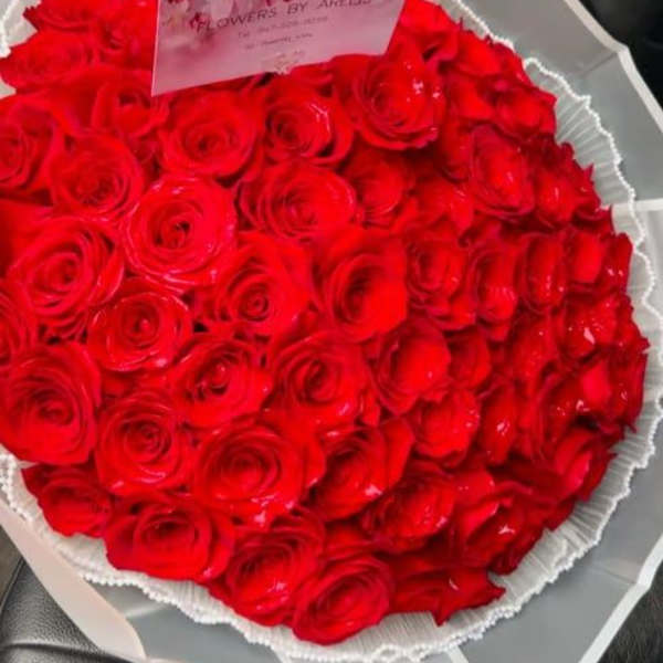 Large bouquet of red roses wrapped in white paper