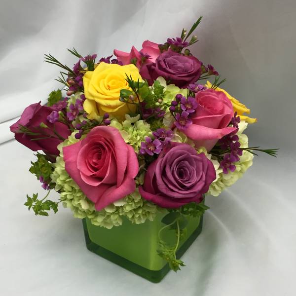 Colorful rose bouquet in a green square vase