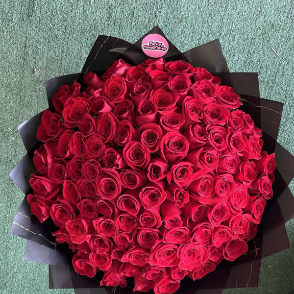 Large bouquet of red roses wrapped in black paper