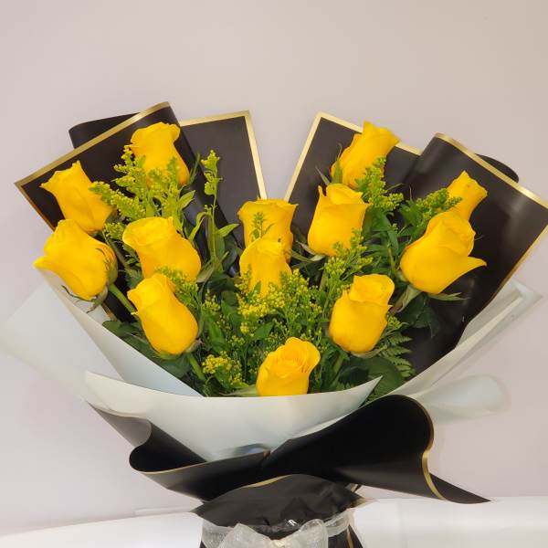 Bouquet of yellow roses wrapped in black and white paper