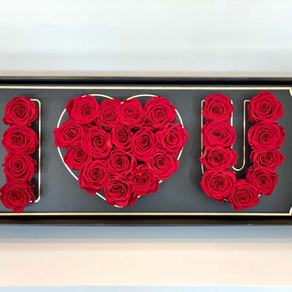 Red roses arranged to spell "I ♥ U" in a framed display