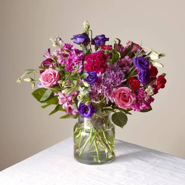 Mixed pink and purple bouquet in a clear glass vase