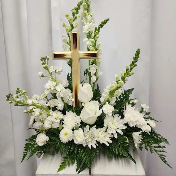 White floral arrangement with a wooden cross centerpiece