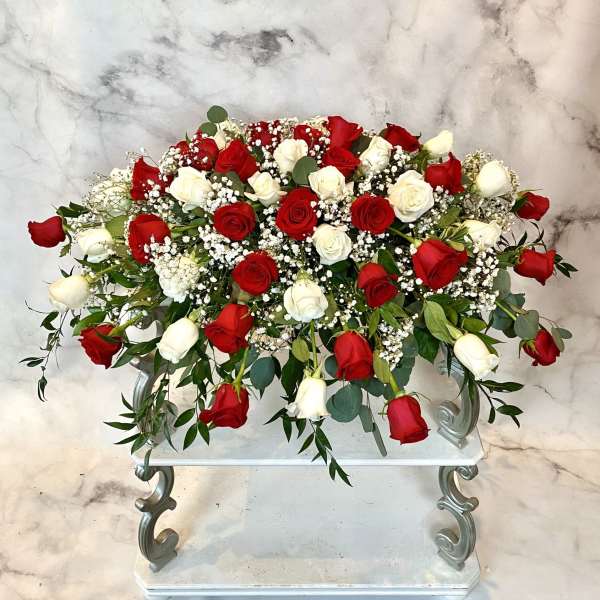 Large arrangement of red and white roses on a stand