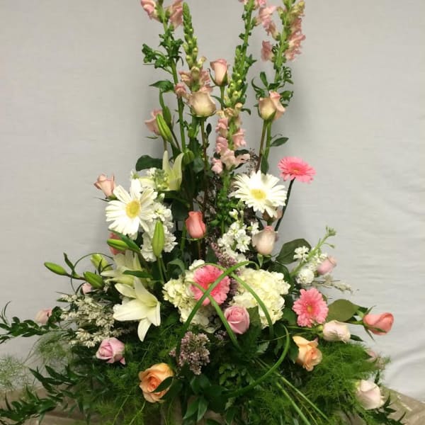 Tall mixed flower arrangement with pink roses, white lilies, and daisies