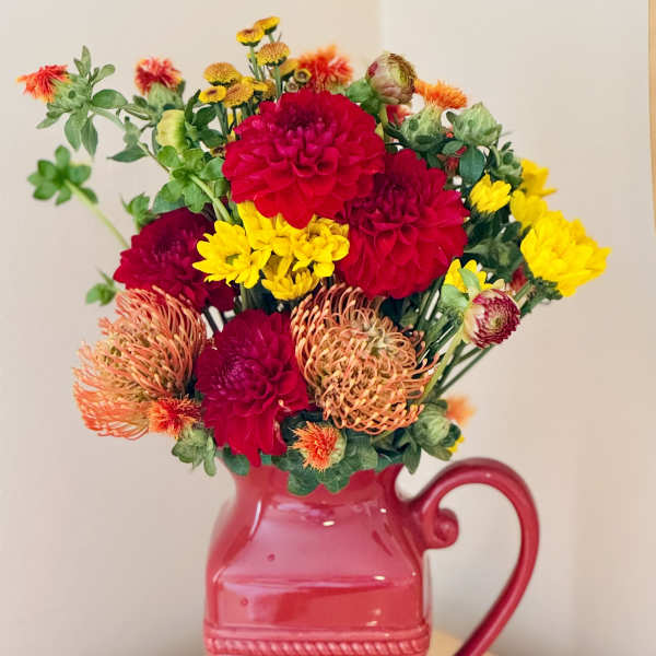 Bright mixed bouquet in a pink pitcher vase