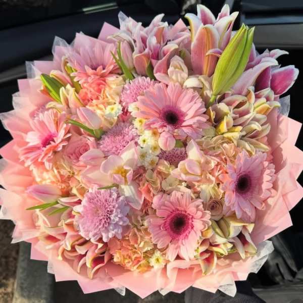 Pink mixed bouquet with gerbera daisies and lilies wrapped in pastel paper