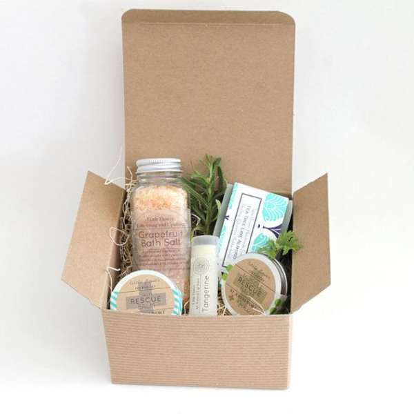 Open cardboard gift box with bath and skincare items