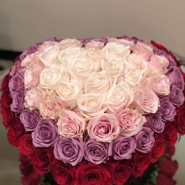 Heart-shaped bouquet of pink, purple, and red roses