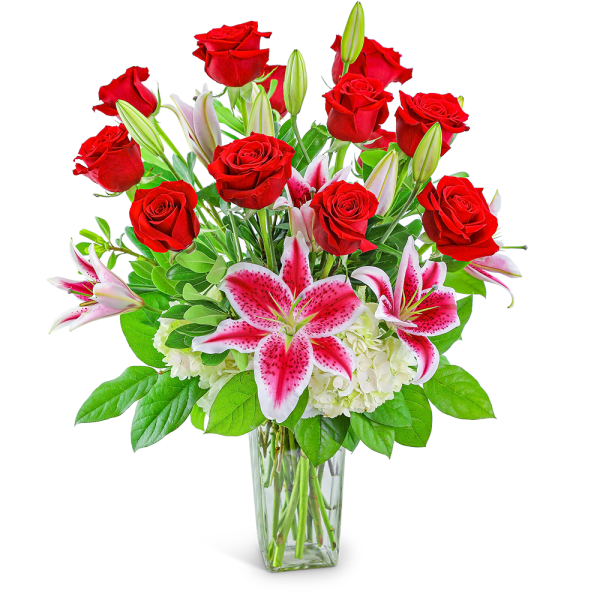 Bouquet of red roses and pink lilies in a clear glass vase