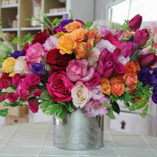Colorful bouquet of roses and tulips in a silver vase