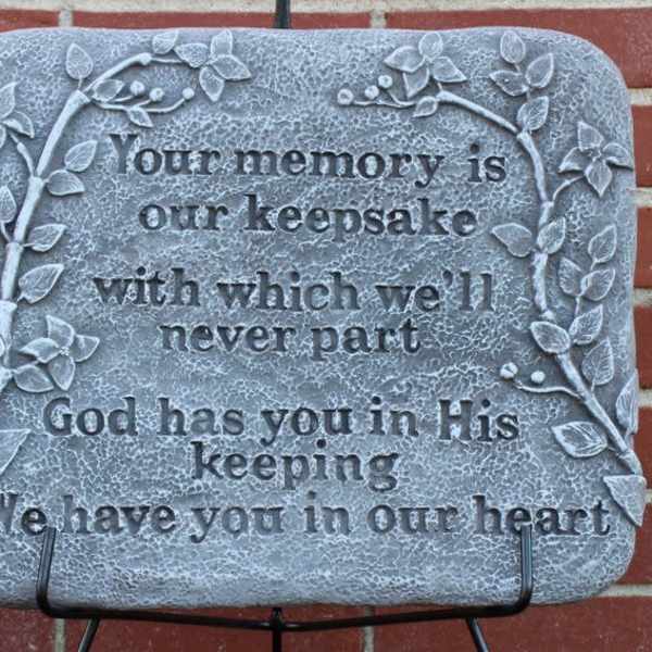 Memorial plaque with a sympathy quote on a brick wall