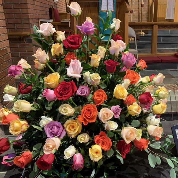 Large arrangement of multicolored roses in a church setting