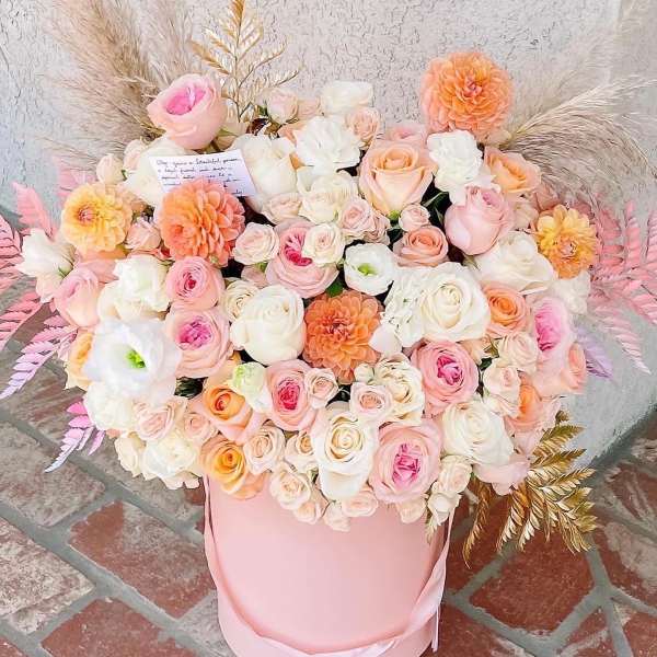 Large pastel bouquet of roses and dahlias in a pink hat box