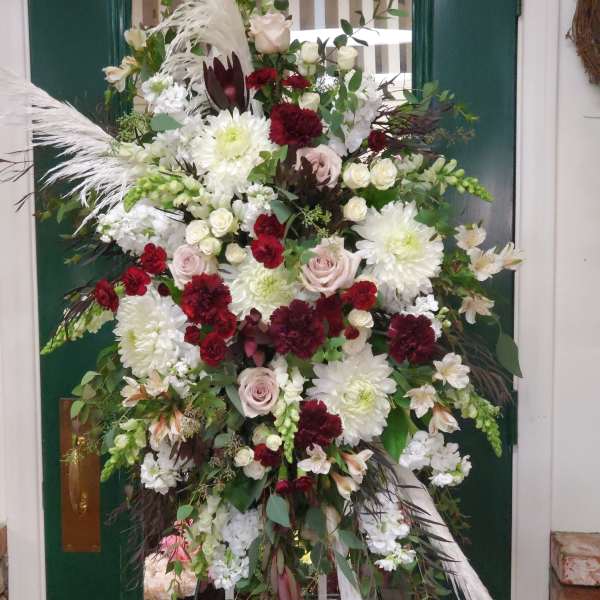 Large standing floral spray with white, blush, and burgundy blooms