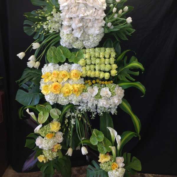 Large floral standing arrangement with white and yellow roses and calla lilies