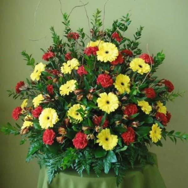 Large arrangement of yellow daisies and red carnations