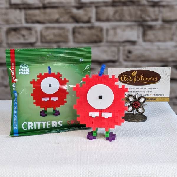 Toy building-block critter figures beside packaged blocks and a flower shop card