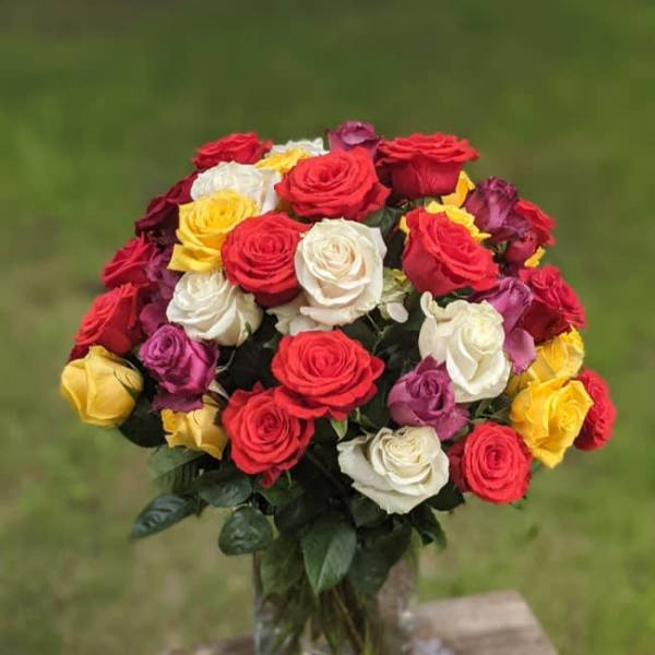Bouquet of multicolored roses in a clear glass vase