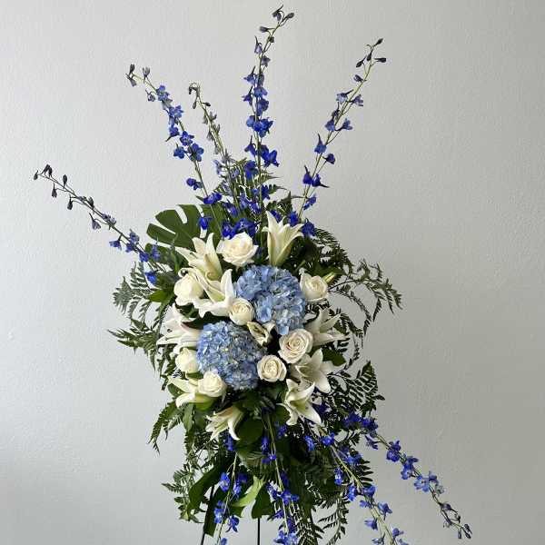 Tall floral spray with blue and white flowers on a stand