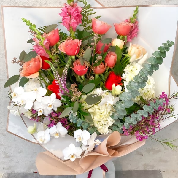 Bouquet of pink and white flowers with eucalyptus in white wrapping
